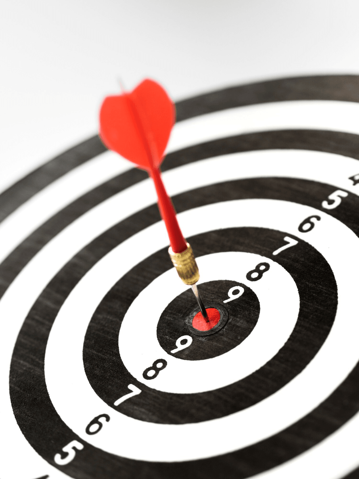Dartboard with red dart hitting bullseye target